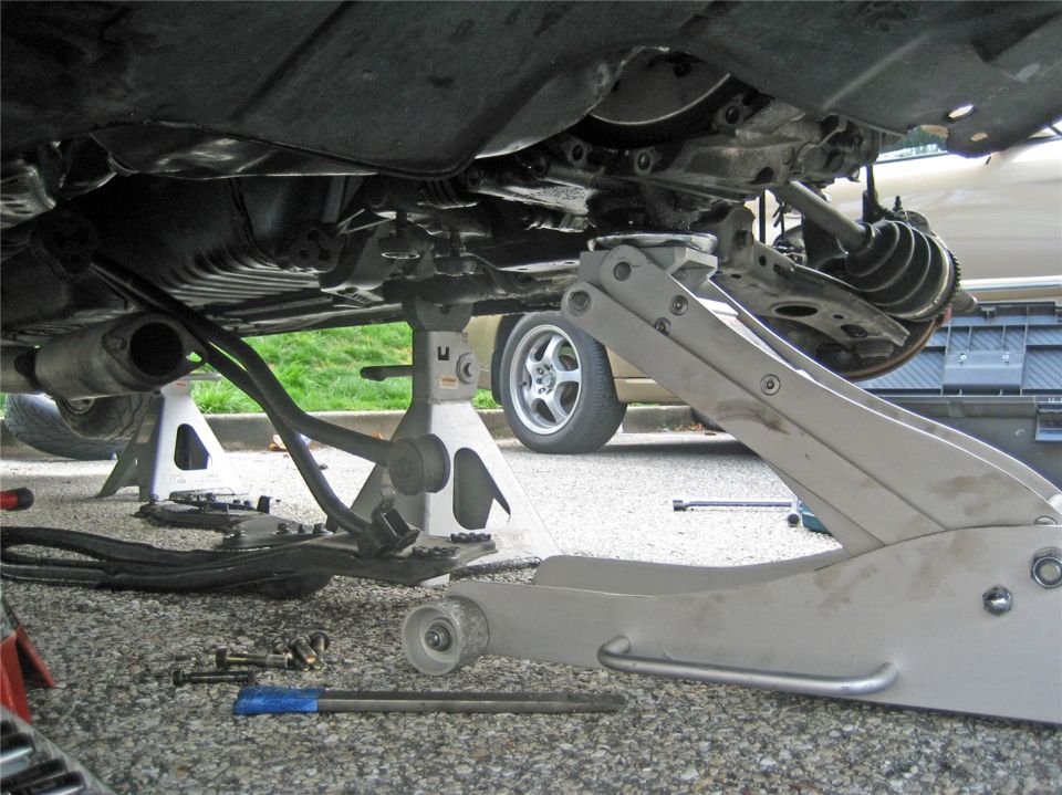 1993 Ford Probe GT underbody with suspension components visible, supported by jack stands and a floor jack