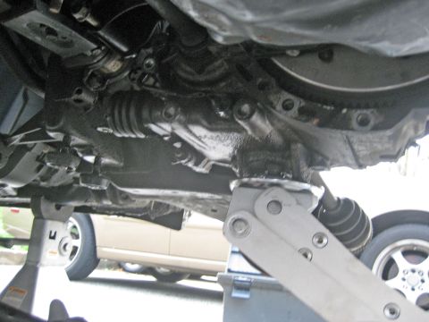 1993 Ford Probe - Vehicle undercarriage repair work in progress, with another car in the background.