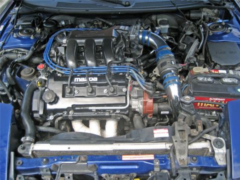 1993 Ford Probe - The engine bay features a Mazda engine with blue spark plug wires and a chrome intake pipe.