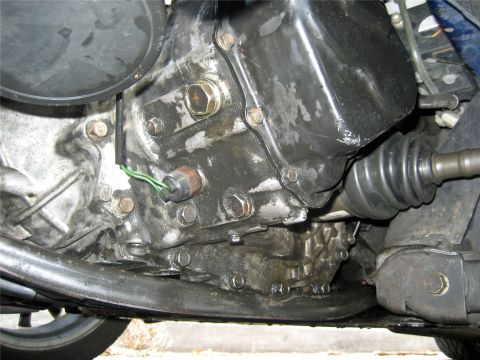 1993 Ford Probe - Close-up view of the engine oil pan and transmission assembly, showing a sensor with green wires.
