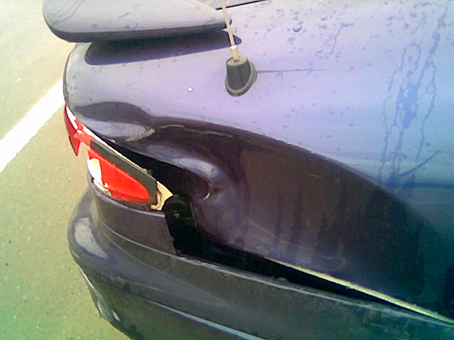Purple car's rear quarter panel and taillight are damaged