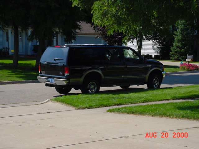 Black SUV parked on grass, timestamped Aug 20, 2000