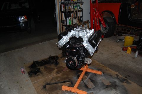 1994 Ford Bronco - Engine on a stand in a garage, with other vehicles partially visible.