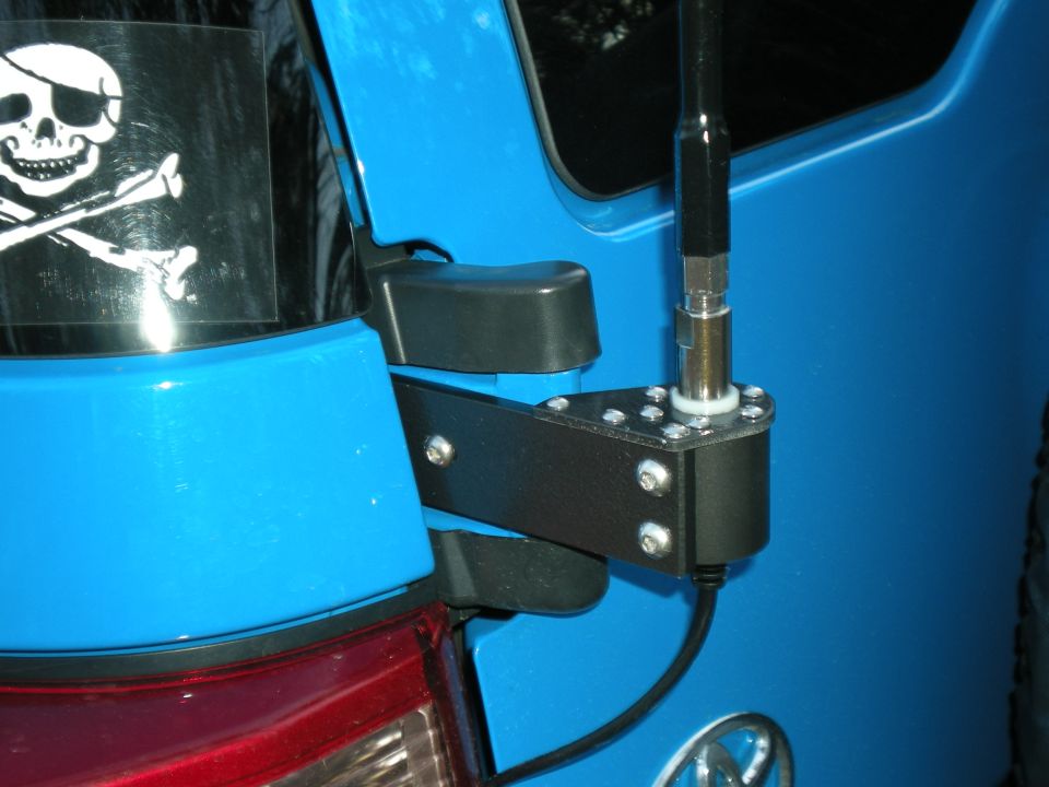 Whip antenna on a black bracket mounted to a blue Toyota SUV rear hatch