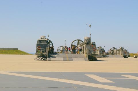 1986 Ford Bronco - Multiple hovercrafts are lined up on an airfield with people boarding one of them.