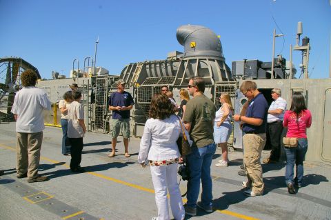 1986 Ford Bronco - Tour group observes the large engine and exhaust system of a hovercraft on a sunny day.