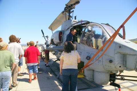 1986 Ford Bronco - Crowd observes an AH-1 Cobra attack helicopter during an outdoor event.