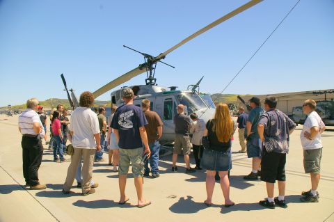 1986 Ford Bronco - A group of people observe a helicopter on a sunny day at an outdoor event.