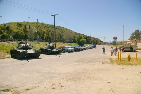 1986 Ford Bronco - A military scene two tanks and a row of SUVs parked on a sunny day.