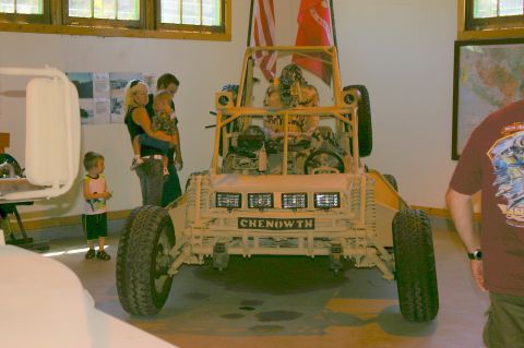 1986 Ford Bronco - A Chenowth dune buggy is on display, with people observing it in the background.