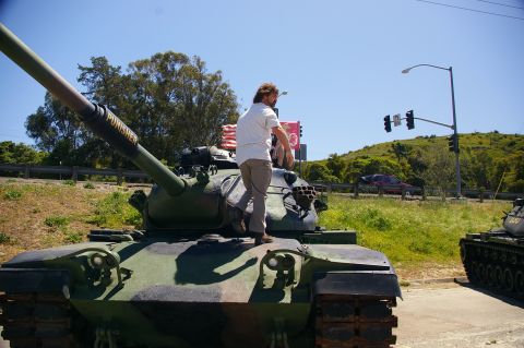 1986 Ford Bronco - A man stands atop a camouflaged tank with "PUNISHER" written on its barrel, with another tank visible to the right.