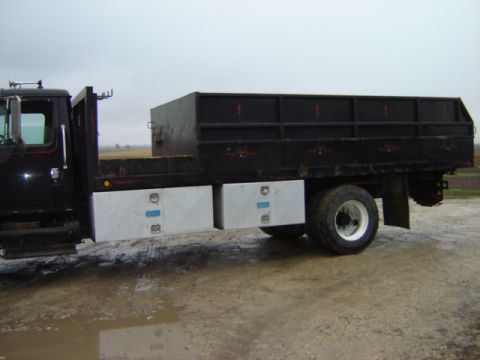 1992 Ford Bronco - A black flatbed truck with dual rear wheels and two silver toolboxes mounted on the side is shown from the side view.