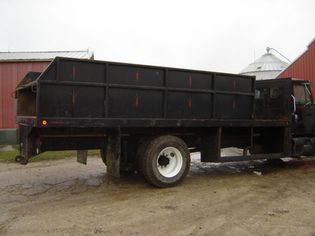 Black flatbed truck with red accents on the side panels, seen from the side