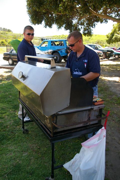1986 Ford Bronco - A blue off-road vehicle with custom graphics is visible in the background of a barbecue scene.