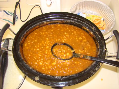 1986 Ford Bronco - A slow cooker is filled with baked beans, with a ladle resting inside.