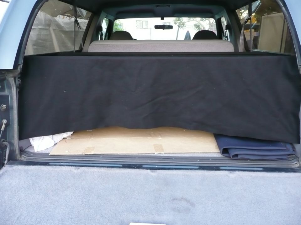 1991 Ford Bronco interior cargo area with black cargo cover and cardboard