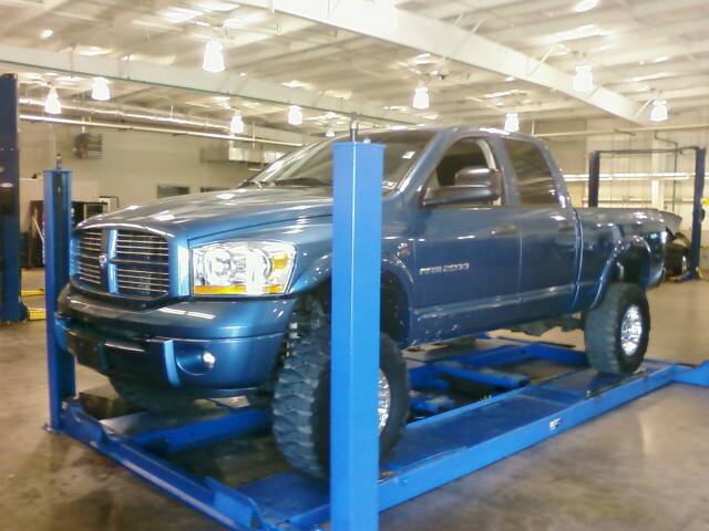 Blue 2006 Dodge 2500 pickup truck on a blue lift, front 3/4 view