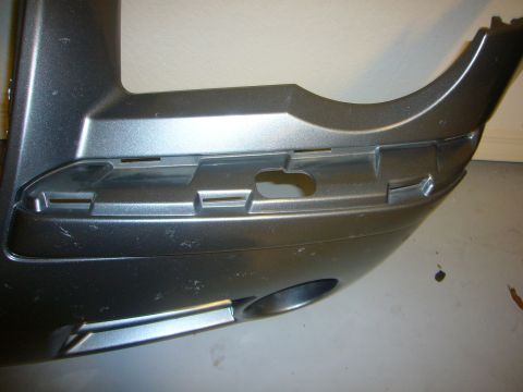 2007 Chrysler 300 - A gray car bumper part is shown from an angle, revealing mounting clips and a circular opening.