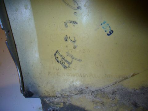 2007 Chrysler 300 - Car bumper part with molded text 'MADE IN CANADA BY POLYMERICOMP' and handwritten markings.
