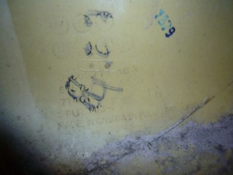 2007 Chrysler 300 - A yellow plastic part, possibly a bumper component, shows manufacturing details and handwritten marks.
