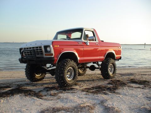 1978 Ford Bronco - This lifted 1978 Ford Bronco is parked on a beach with the ocean in the background.