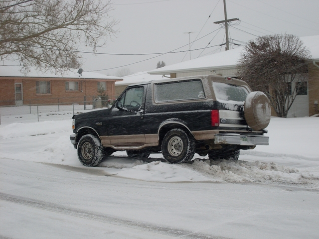 1996 Ford Bronco in snow, rear quarter view, black and tan