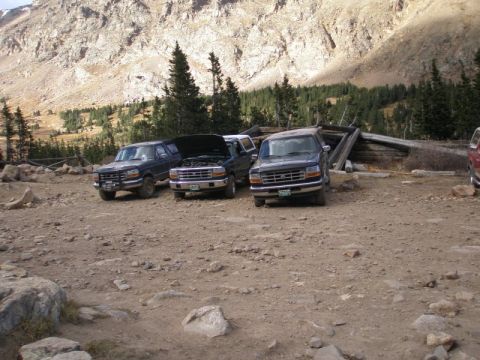 1996 Ford Bronco - Three 1996 Ford Broncos are parked in a mountainous landscape, with one hood open.