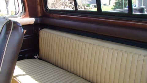 1979 Ford F-350 - The interior of a truck shows a tan bench seat with brown trim and a view out the window.