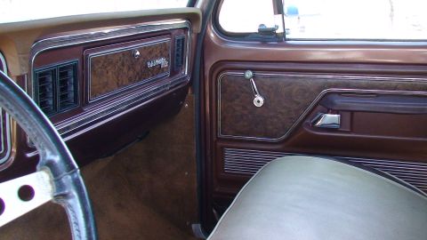 1979 Ford F-350 - The interior of a 1979 Ford F-350 Supercab features woodgrain trim and a "Ranger XLT" badge.