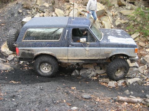 1991 Ford Bronco - A Ford Bronco navigates a challenging rocky trail, demonstrating its off-road capabilities.