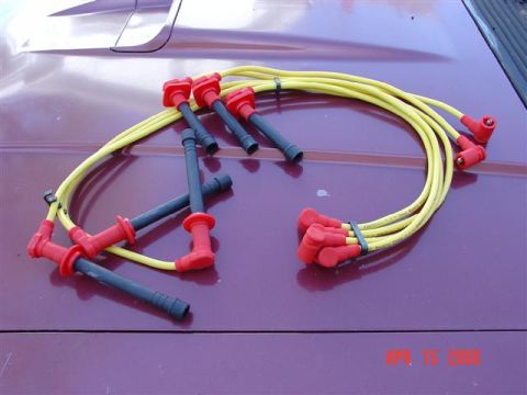 1993 Ford Probe - Spark plug wires are laid out on a car's hood or trunk lid.