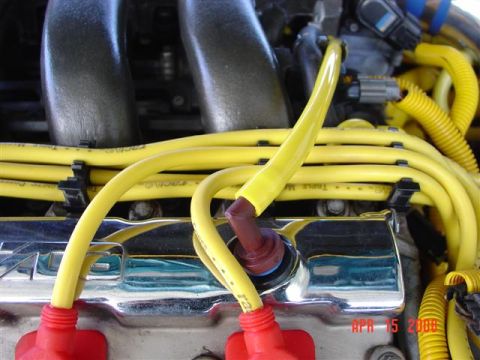1993 Ford Probe - Close-up of an engine bay, showing yellow spark plug wires and red spark plug boots.