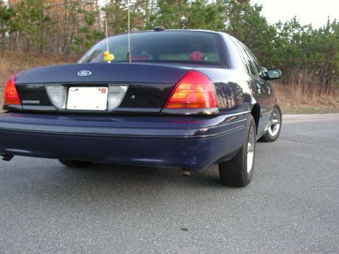 1999 Ford Crown Victoria - Rear view of a dark blue 1999 Ford Crown Victoria sedan parked on a road.