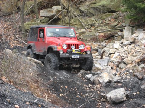 1991 Ford Bronco - Jeep Wrangler Rubicon navigating a challenging rocky off-road course.