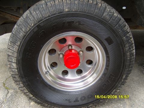 1989 Ford Bronco - A close-up view of a vehicle's wheel and tire, a red center cap and a Big O Tires brand tire.