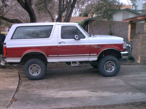 1994 Ford Bronco - This lifted Ford Bronco has a two-tone red and white paint scheme and aftermarket wheels.