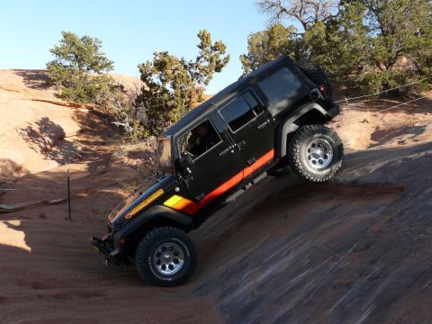 1990 Ford Bronco - Jeep Wrangler navigating a challenging off-road obstacle during an Easter Jeep Safari event.