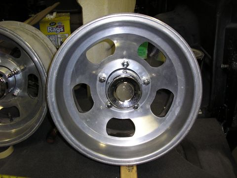 1987 Ford Bronco - A silver aluminum wheel with a chrome center cap is shown in a close-up view.
