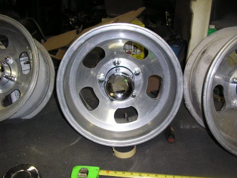 1987 Ford Bronco - Several aluminum alloy wheels are shown, with a tape measure in the foreground.