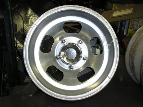 1987 Ford Bronco - Close-up of an aluminum wheel with five oval cutouts and a chrome center cap.