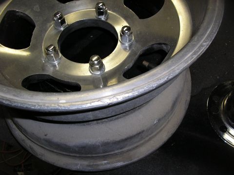 1987 Ford Bronco - A close-up view of a single aluminum wheel, showing the lug nut holes and the rim's edge.