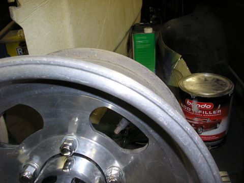 1987 Ford Bronco - Car wheel and Bondo body filler can are shown in this close-up shot.