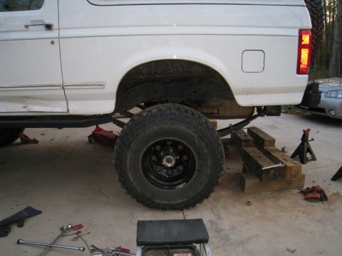 1996 Ford Bronco - This lifted Ford Bronco is undergoing suspension modifications, supported by jacks and wooden blocks.