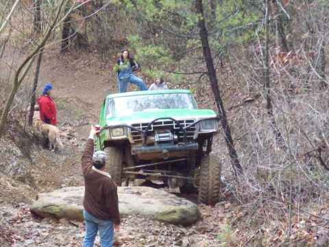 1978 Ford Bronco - A modified 1978 Ford Bronco navigates a challenging off-road course with several people watching.