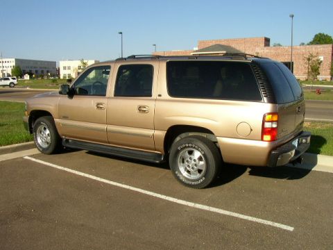 1995 Ford Bronco - This gold SUV is parked in a lot on a sunny day.