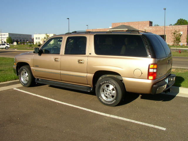 Gold SUV parked in a lot, side view