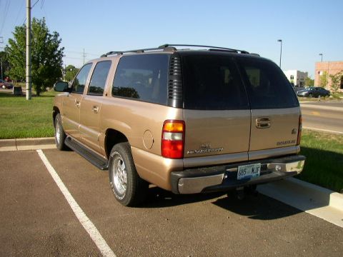 1995 Ford Bronco - This gold SUV is parked in a lot on a sunny day. The rear of the vehicle is visible.