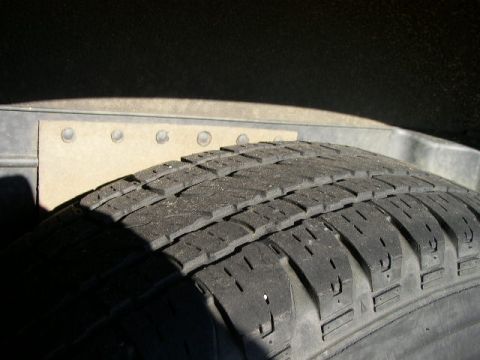 1995 Ford Bronco - Close-up of a tire and the interior of a vehicle's wheel well.