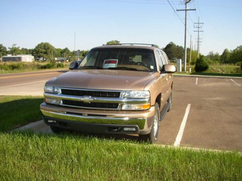 1995 Ford Bronco - A brown SUV is parked in a lot with a "FOR SALE" sign in the window.