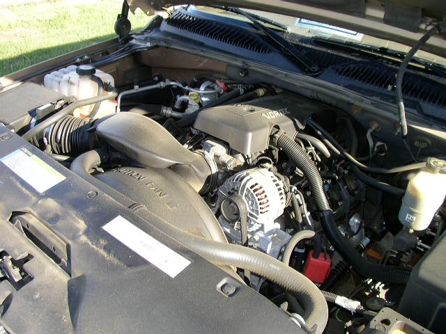 Engine bay with VORTEC engine cover, alternator, and fan shroud. Brown exterior paint visible